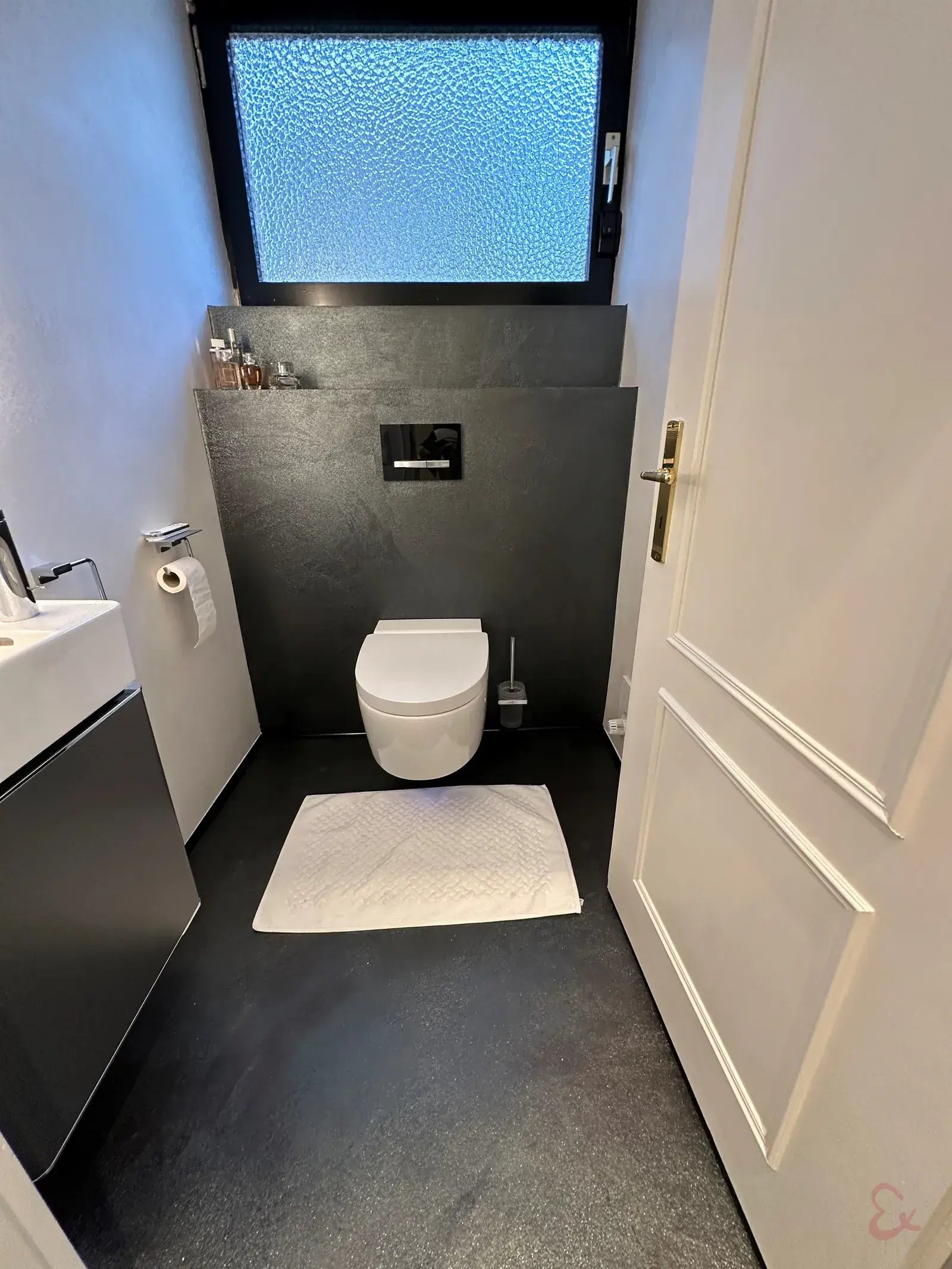 Gäste-WC mit dunkler fugenloser Wand in Hollenstedt