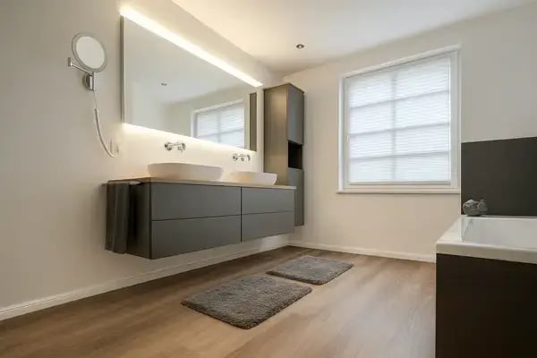 Modernes Bad: schwebender Waschtisch in Dunkelgrau, zwei Aufsatzbecken, LED-Spiegel, Vinyl-Boden und Plissee am Fenster. Modernes Bad: schwebender Waschtisch in Dunkelgrau, zwei Aufsatzbecken, LED-Spiegel, Vinyl-Boden und Plissee am Fenster.