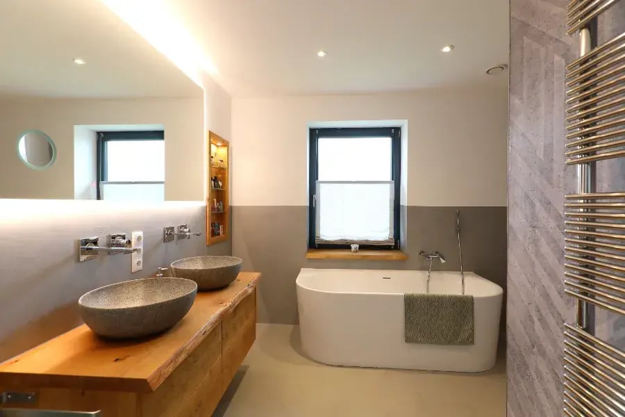 Fugenloses Bad in Moisburg in Naturtönen mit Holzwaschtisch und freistehender Wanne