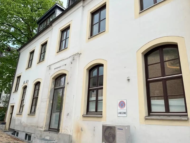 Vorderseite des alten Postamts vor der Sanierung mit Rissen und Verfärbungen