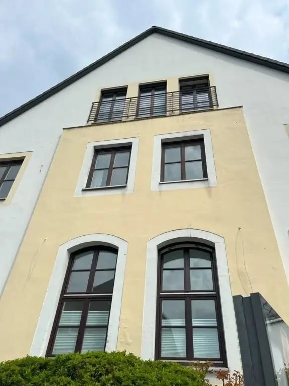 Giebel des alten Postamts in Reinbek vor der Sanierung mit verblasstem Gelb
