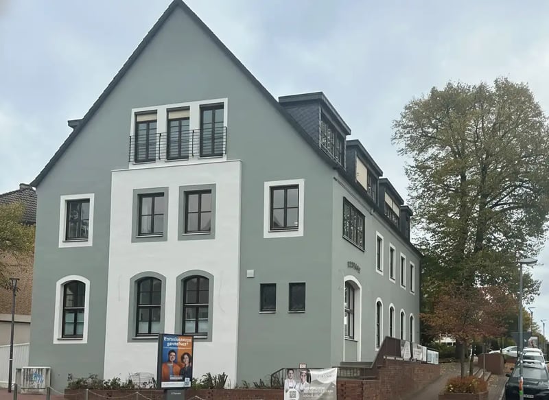 Derselbe Giebel nach der Sanierung in Grau und Weiß