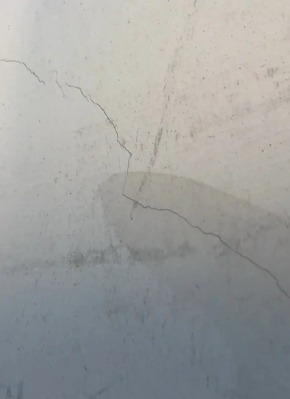 Detail Risse in der Fassade – erdnaher Bereich mit Feuchtigkeitsschäden