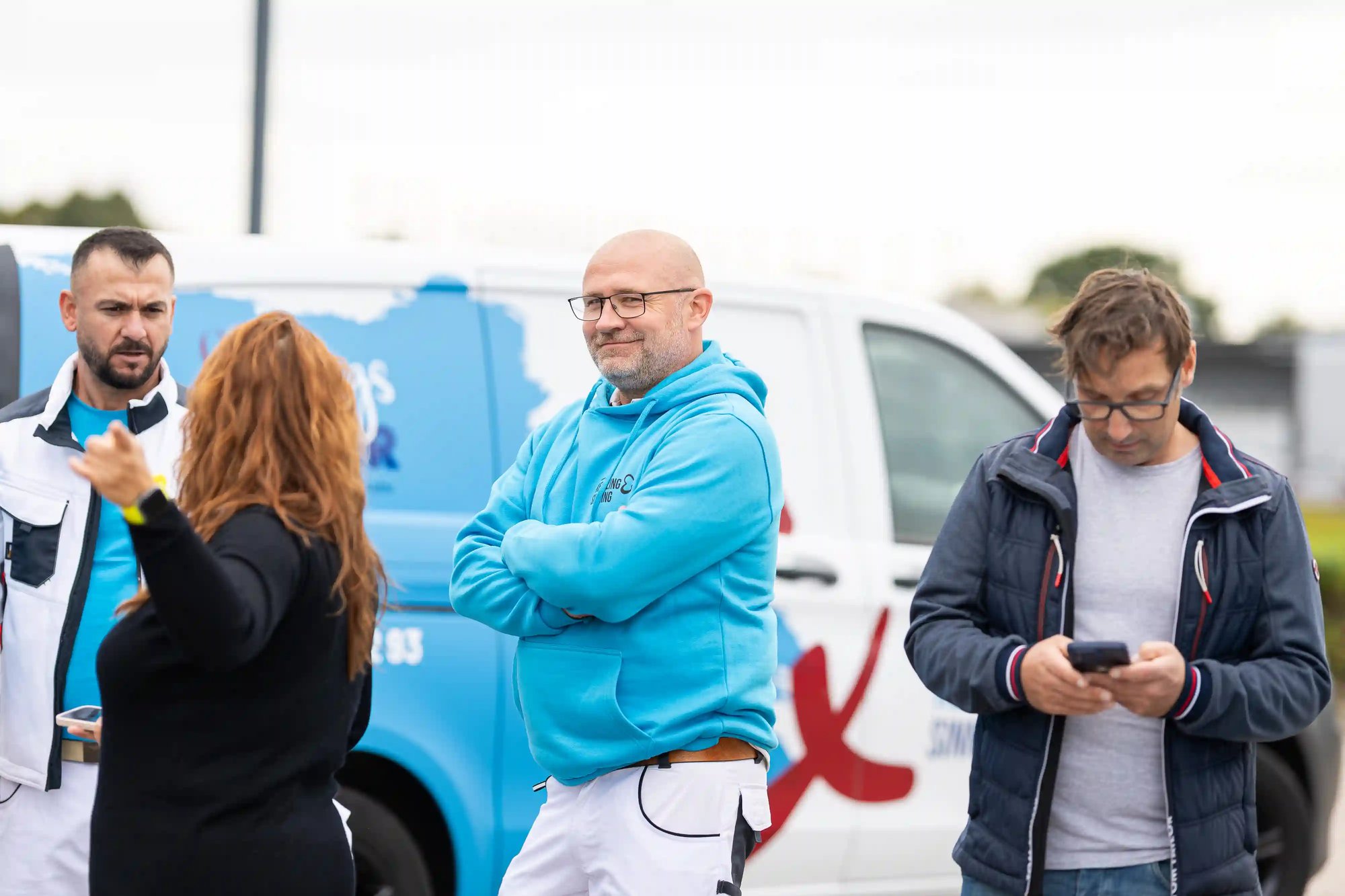 Team von KS Farbkonzepte stimmt sich vor dem Firmenwagen ab – Handwerk, Organisation und Einsatzplanung im Malerbetrieb.