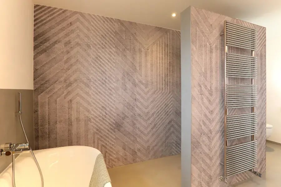 Als stilvoller Kontrast zur Spachteltechnik: Eine hochwertige Designtapete setzt an den Wänden des Badezimmers edle Akzente und sorgt für Wohnlichkeit.